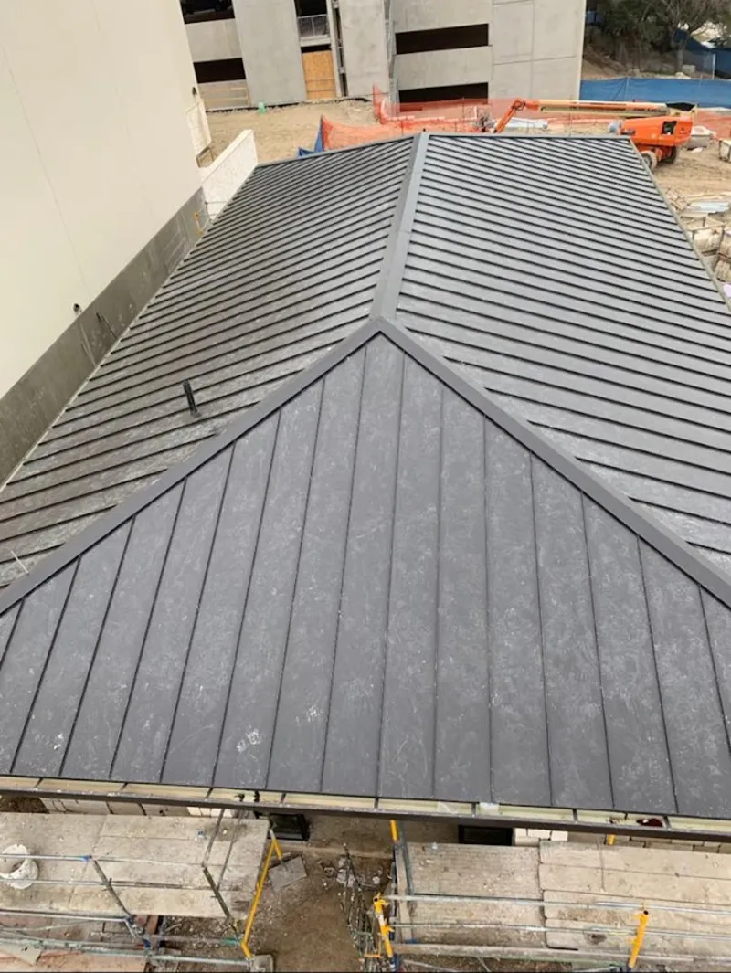 Commercial metal roof construction with crane equipment in Clearfield